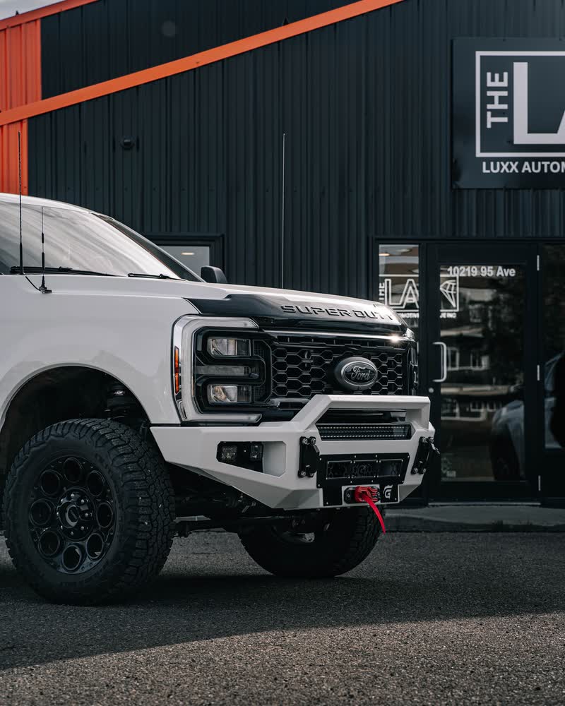 A white Ford Super Duty with a Gridiron winch bumper parked at the front door of THE LAB, 10219 95 Ave
