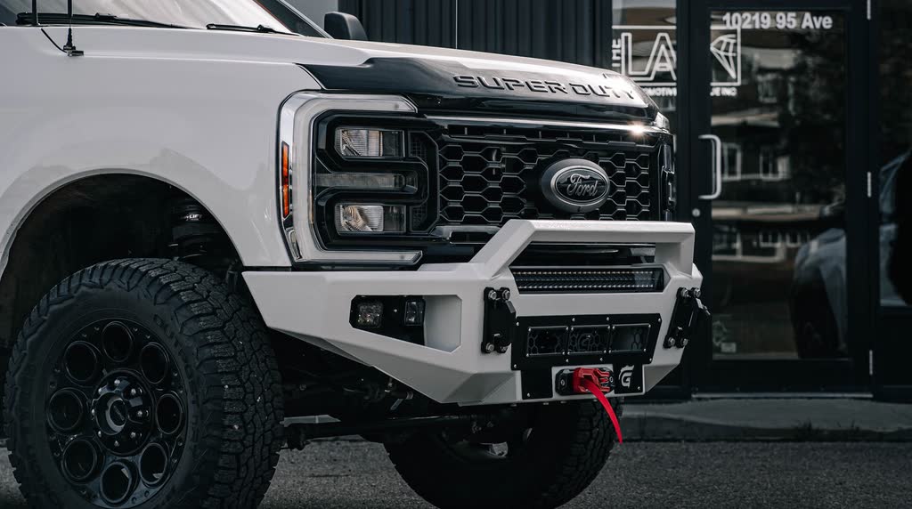 White Ford Super Duty with a Gridiron steel winch bumper outside THE LAB