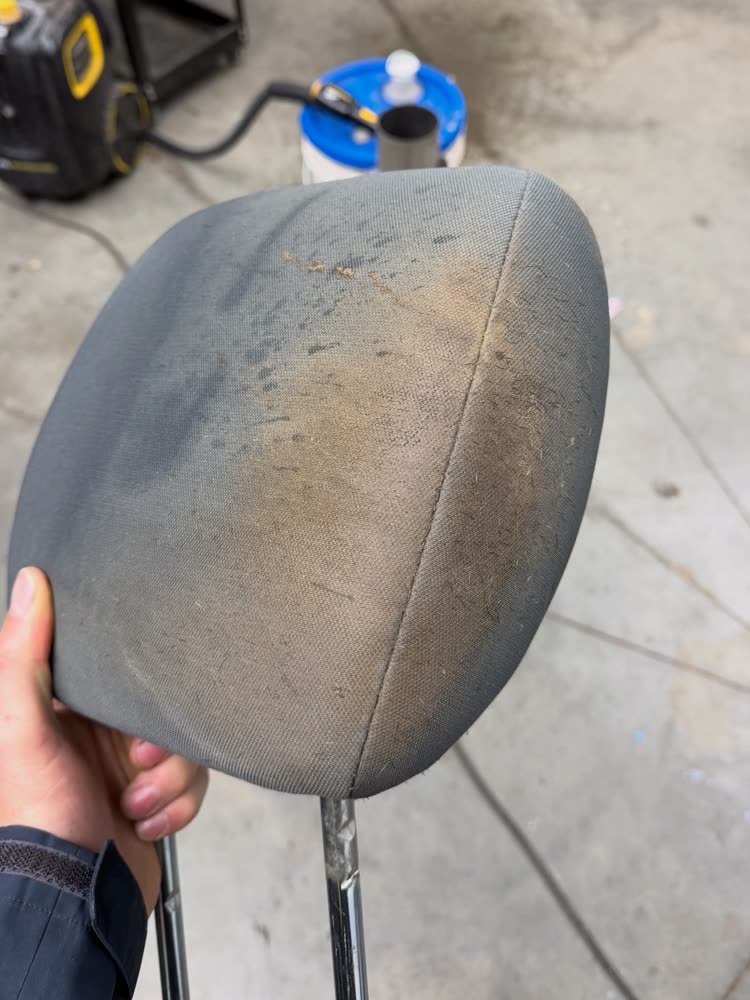 A cloth headrest, stained and dirty, before an interior detail