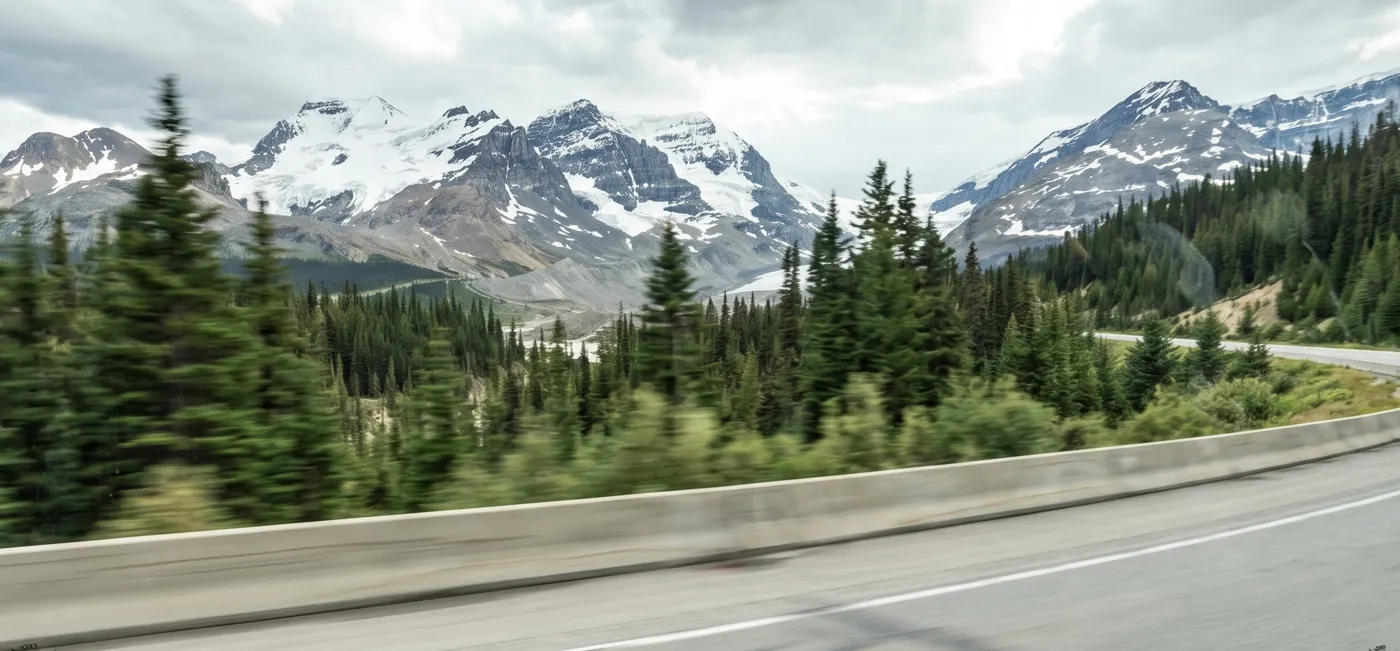 View of mountains and a highway through a vehicle window